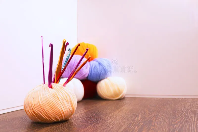 collection-colorful-yarn-balls-crochet-hooks-arranged-wooden-surface-various-shades-including-orange-yellow-382851942-2 Lựa chọn nguyên liệu và dụng cụ phù hợp là bước đầu tiên để tạo nên chiếc yếm hoàn hảo